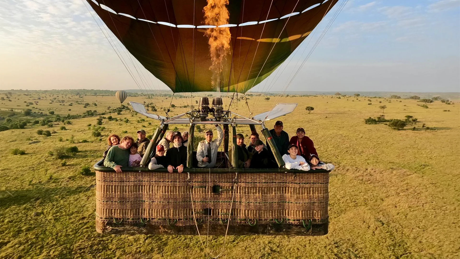 Guests enjoying a sunrise hot air balloon safari over the Serengeti plains